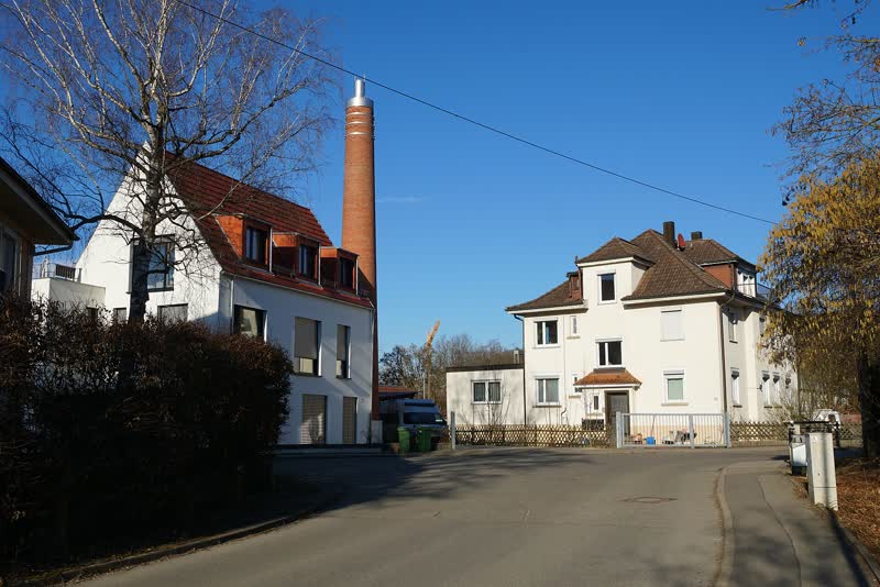 Der hohe Backsteinkamin der ehemaligen Ölmühle Wohlbold zwischen Wohnhäusern